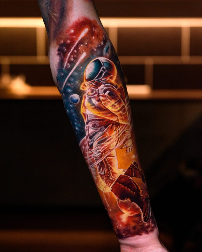 Colorful astronaut tattoo sleeve showcasing vibrant cosmic elements, emphasizing artistic flow and cohesion, reflecting personal meaning and visual style.