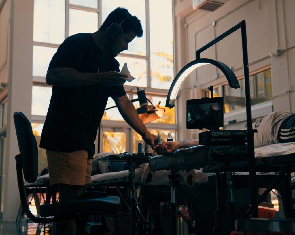 A shadow figure of a tattoo artist at Inked Miami, prepping his tattoo station