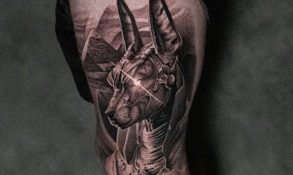 Tattoo of a stylized Anubis figure on a person's arm, showcasing detailed black and gray ink work, reflecting the artistry of body art discussed in debunking tattoo misconceptions.