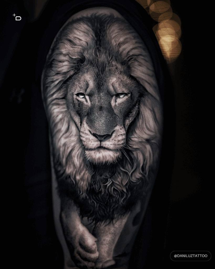 Black and grey realism tattoo of a lion on an upper arm