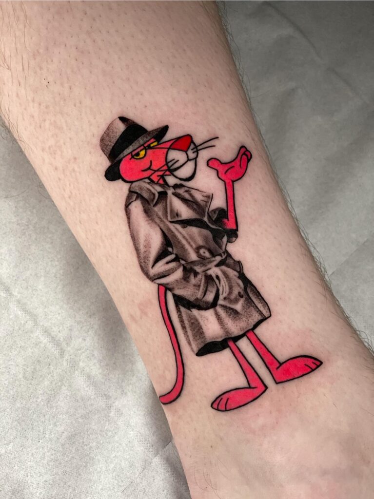 Tattoo of the Pink Panther in black-and-grey realism detective coat, combined with bright cartoon-style linework and color