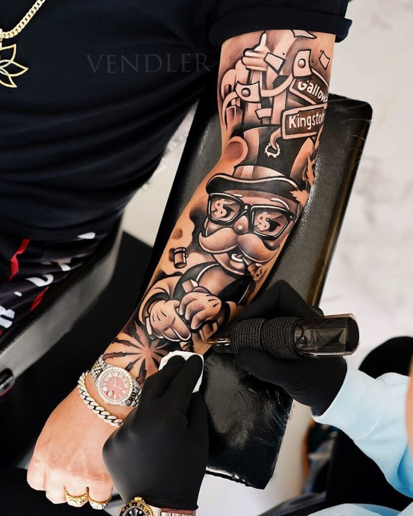 Artist tattooing a forearm sleeve featuring a stylized Monopoly man design with blackwork and black-and-gray shading