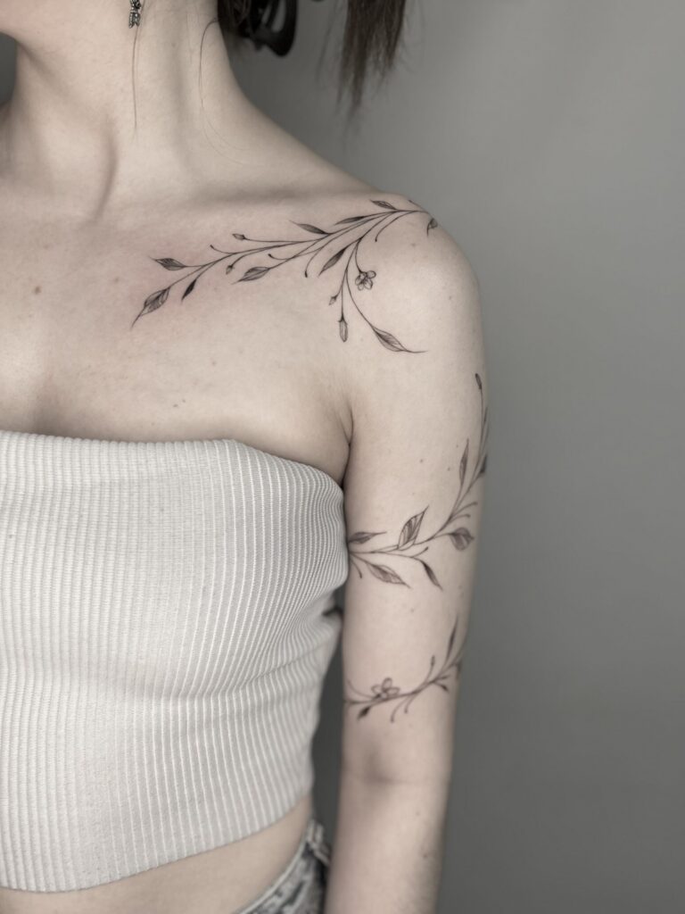 a floral realism tattoo that wraps around an arm